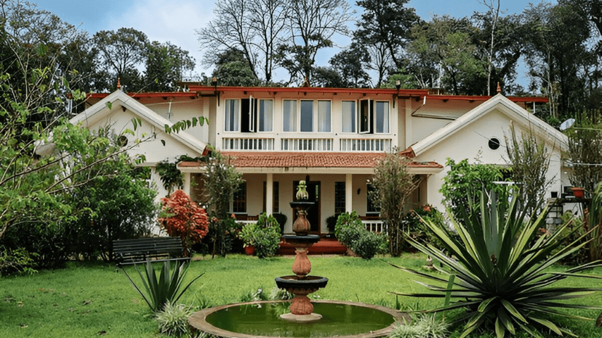 A beautiful residential villa in Bengaluru with a striking fountain positioned in the middle of the yard, adding charm to the greenery.