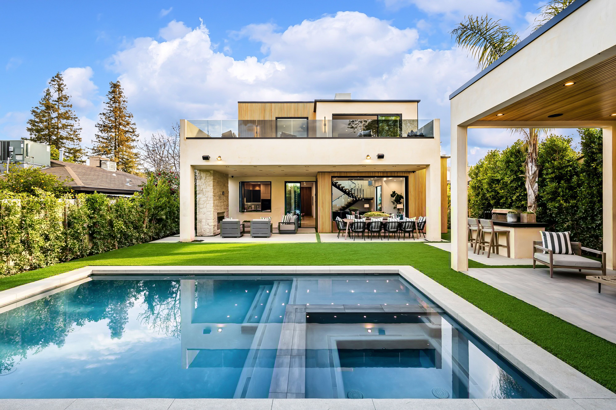 Modern luxury house with a swimming pool and outdoor seating.
