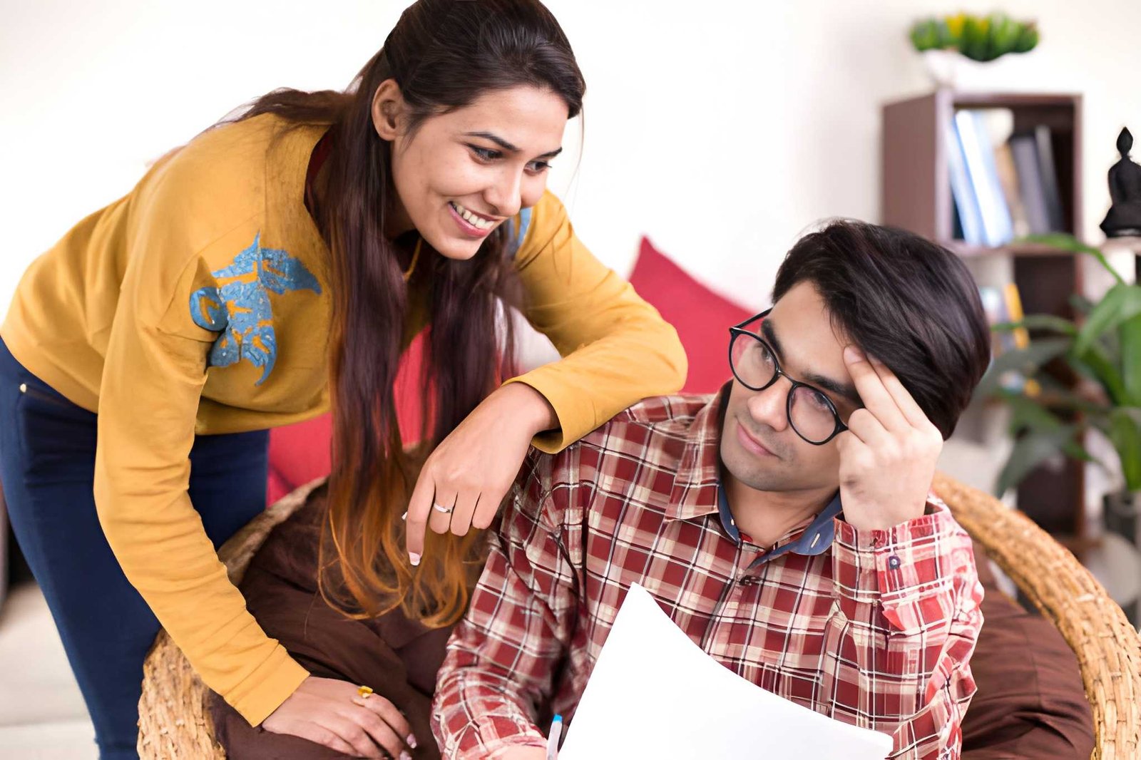A couple making a homebuyer checklist with documents and keys on wooden table