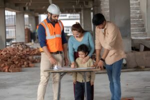 Property inspection before flat possession with a family and site engineer reviewing construction plans at an under-construction apartment.
